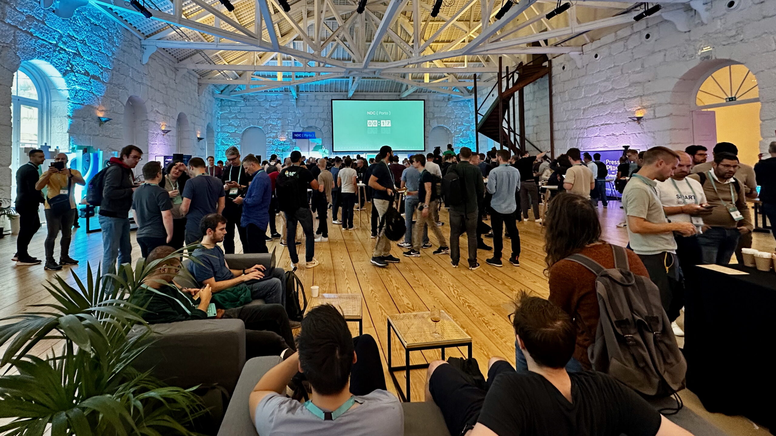 A crowd of software developers inside the Alfandega Conference Centre in Porto, Portugal, awaiting the start of the NDC Porto 2024 conference.